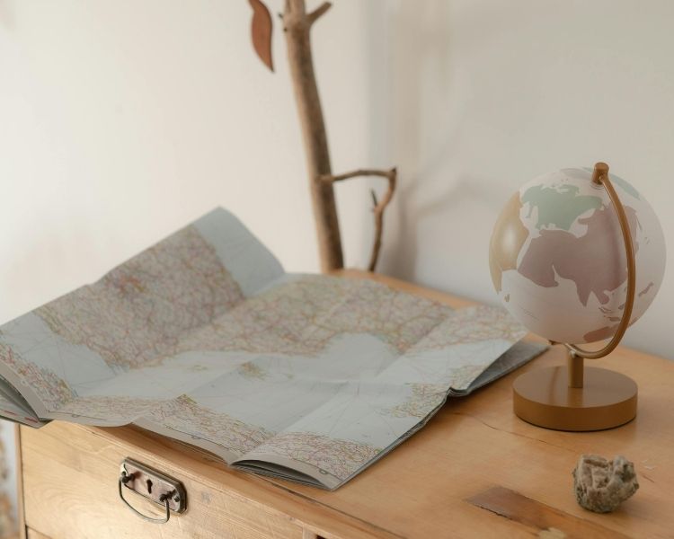 Services traduction freelance Globe terrestre posé sur une table à côté d'une carte du monde.