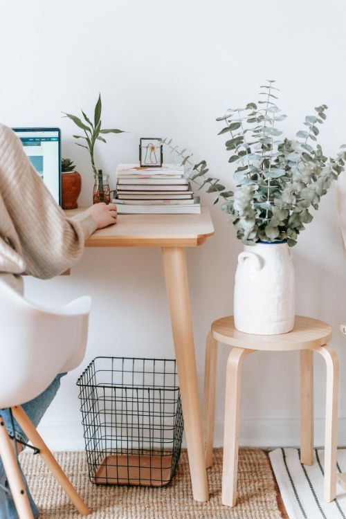 Traduction freelance tech et marketing Traductrice à son bureau à côté d'une pile de livres et d'une plante verte